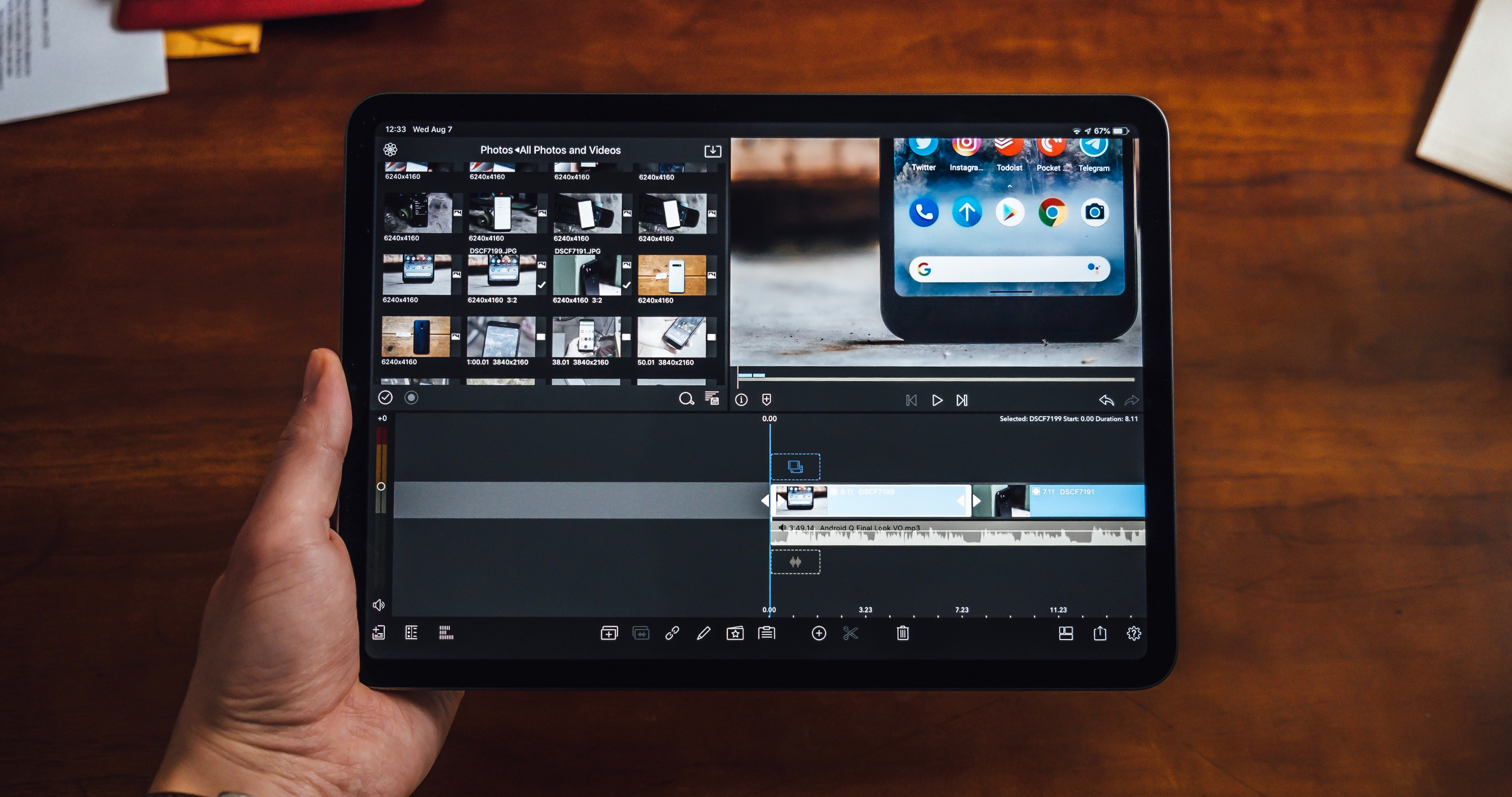 Overhead photo of person holding a tablet with video editing software in the screen.